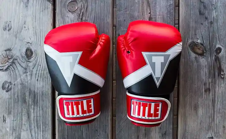 Pair of boxing gloves on gray wood background